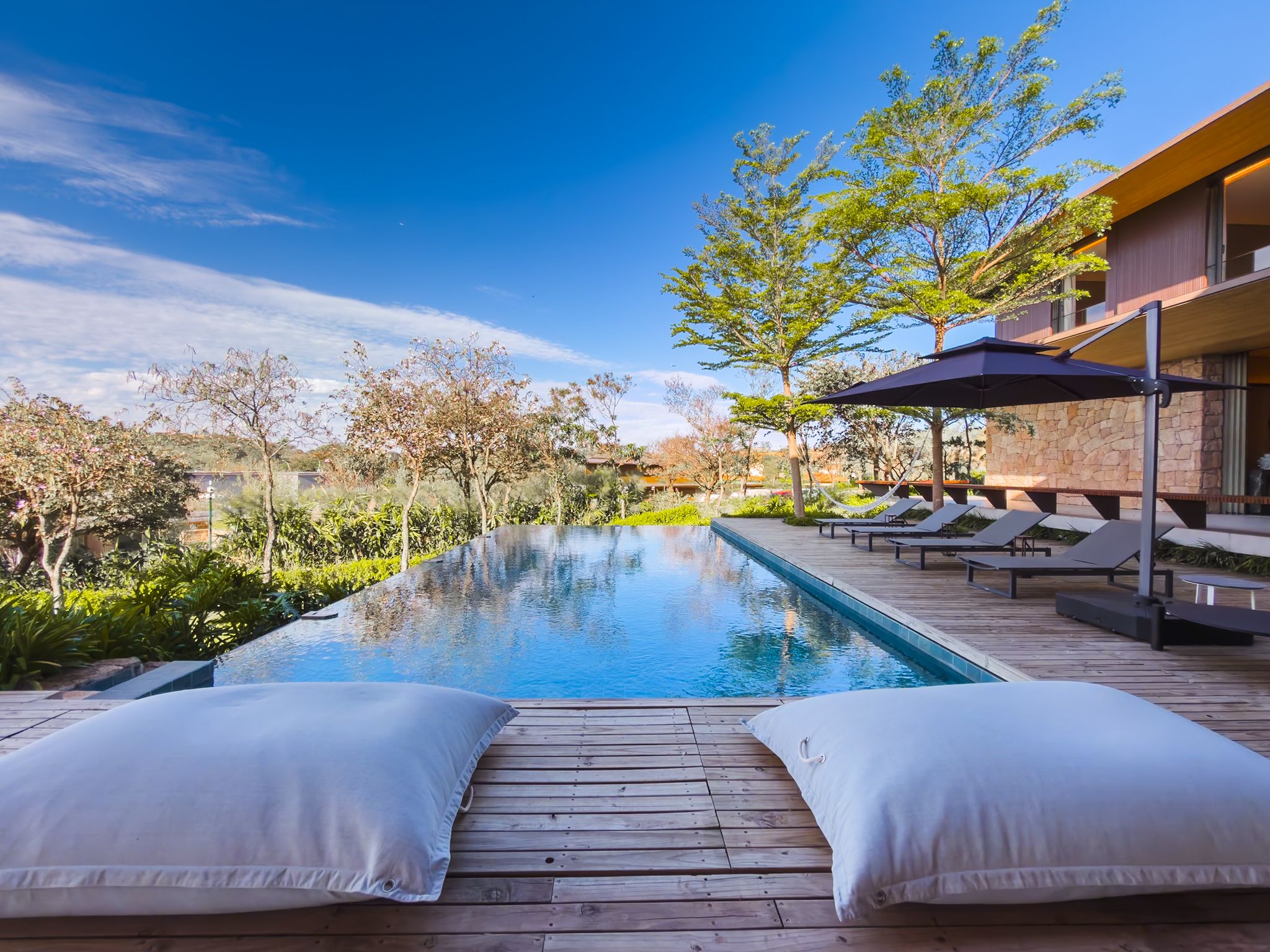 Casa de arquitetura premiada na Fazenda da Grama, com piscina de borda infinita e vista para o lago